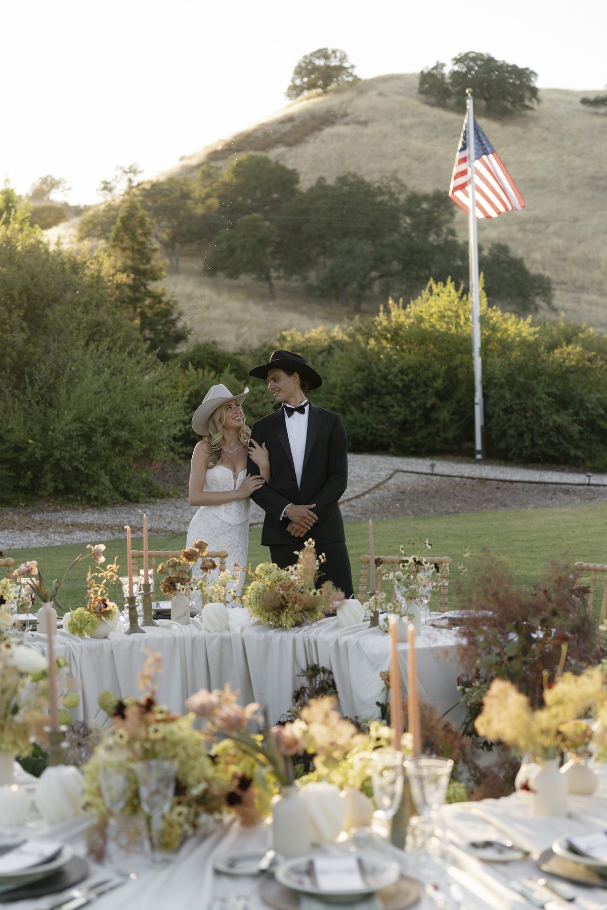 The couple among the dinner tables on the lawn