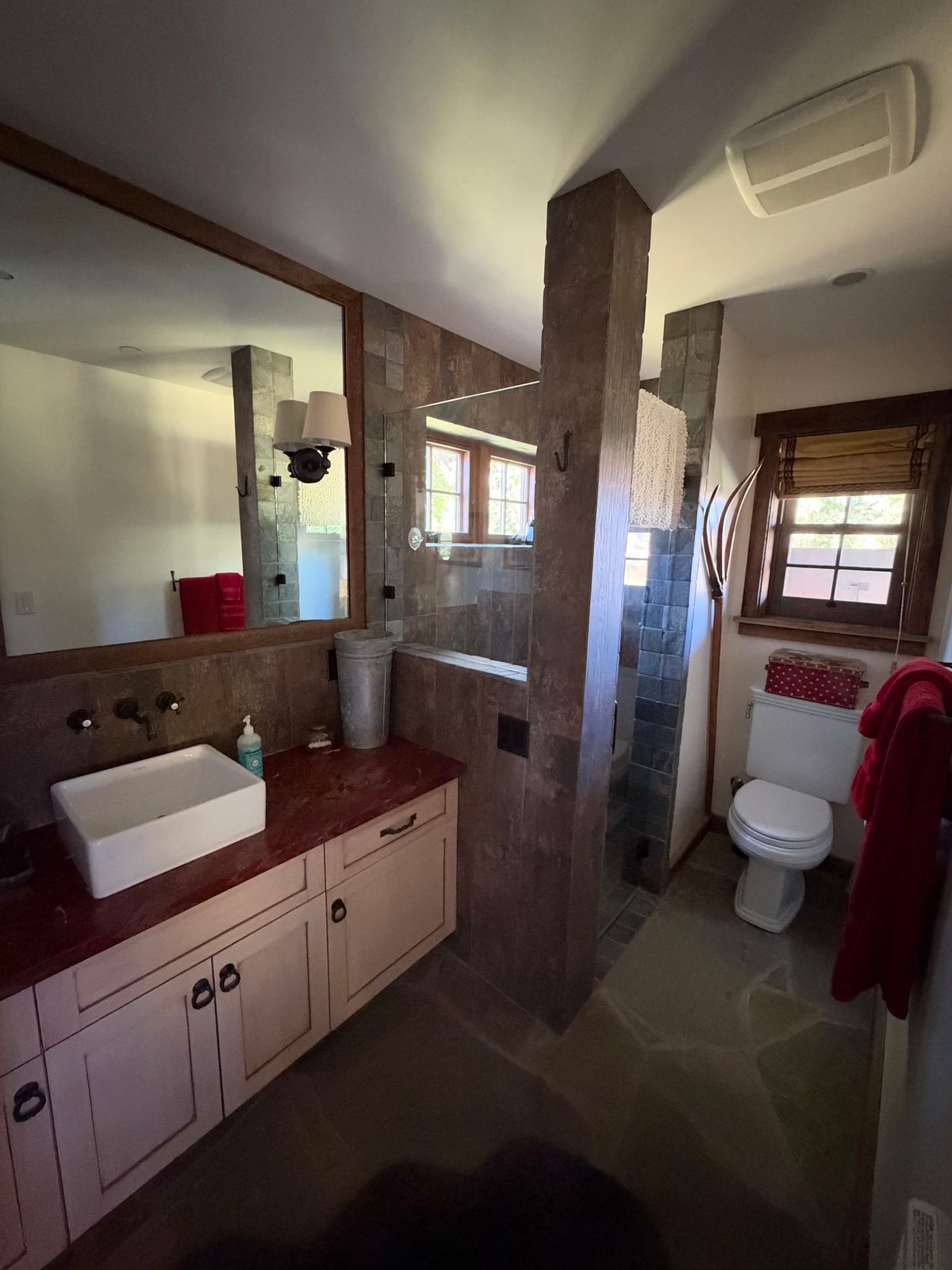 A guest bath with stone counter and walk-in shower